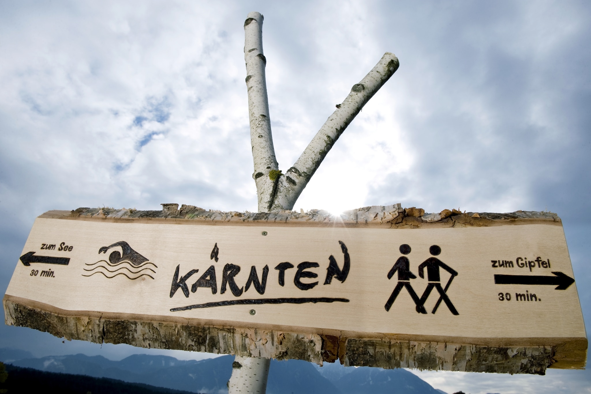 Wegweiser in Kärnten mit Richtungen zum See und zum Gipfel